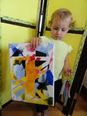 My granddaughter Edie showing the artwork she made in the Lindleys' toddler class.
